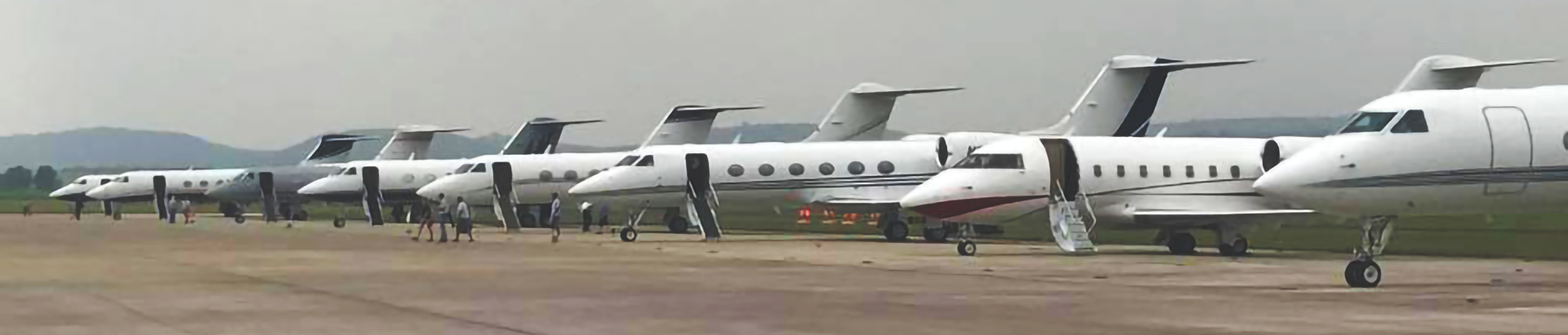 Small jets lined up on the airport apron